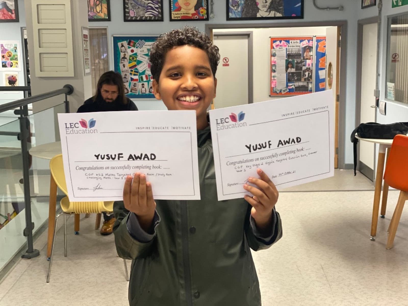 Student celebrating completed Maths and English books at LEC